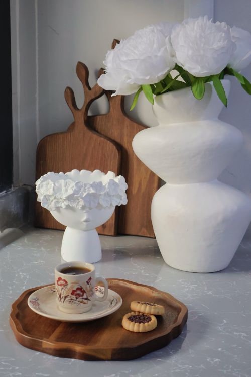 Free Stylish coffee cup and cookies on wooden tray with elegant floral decor. Stock Photo