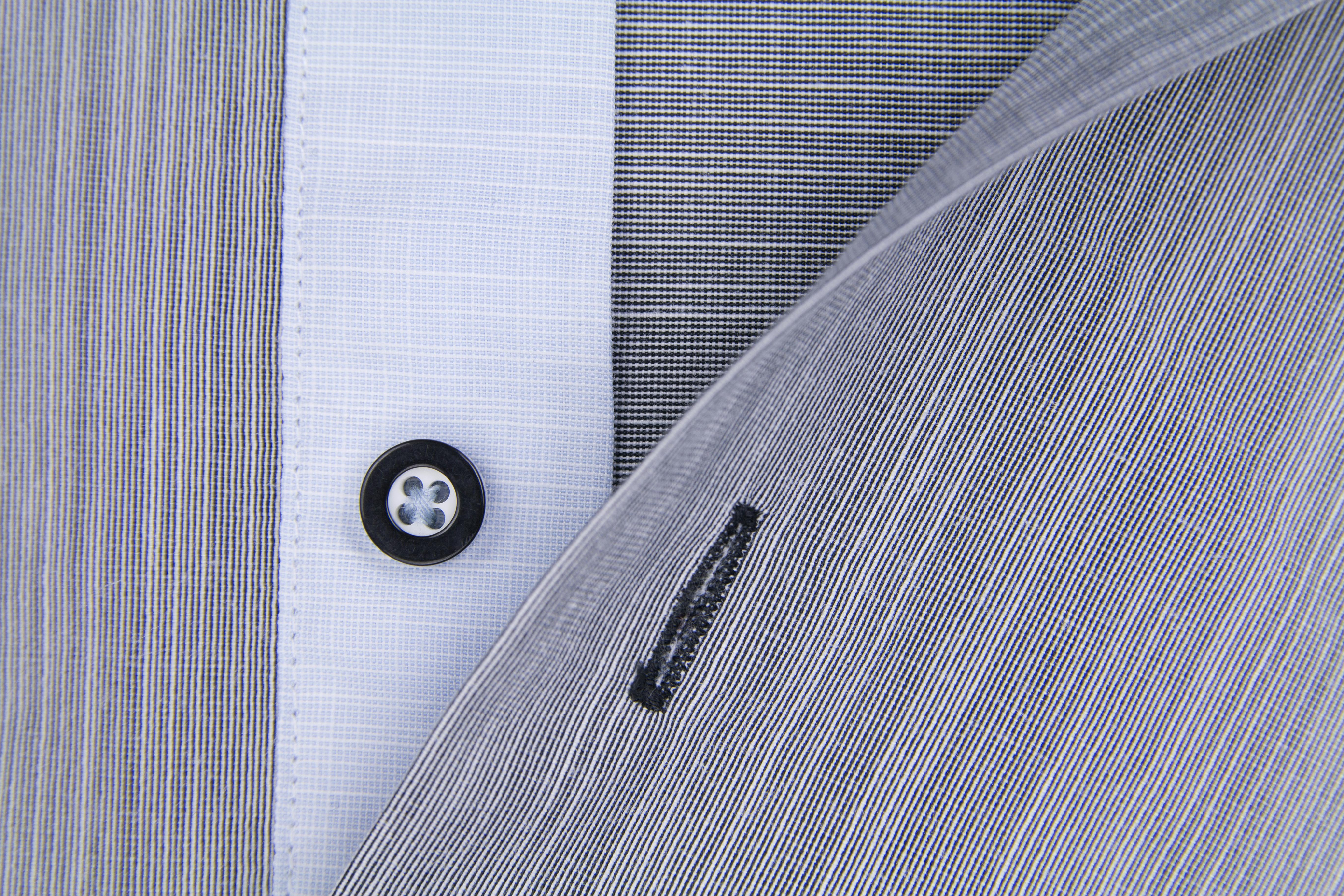 grátis Fotografia macro detalhada do tecido de uma camisa social com botão preto e costura fina. Foto profissional