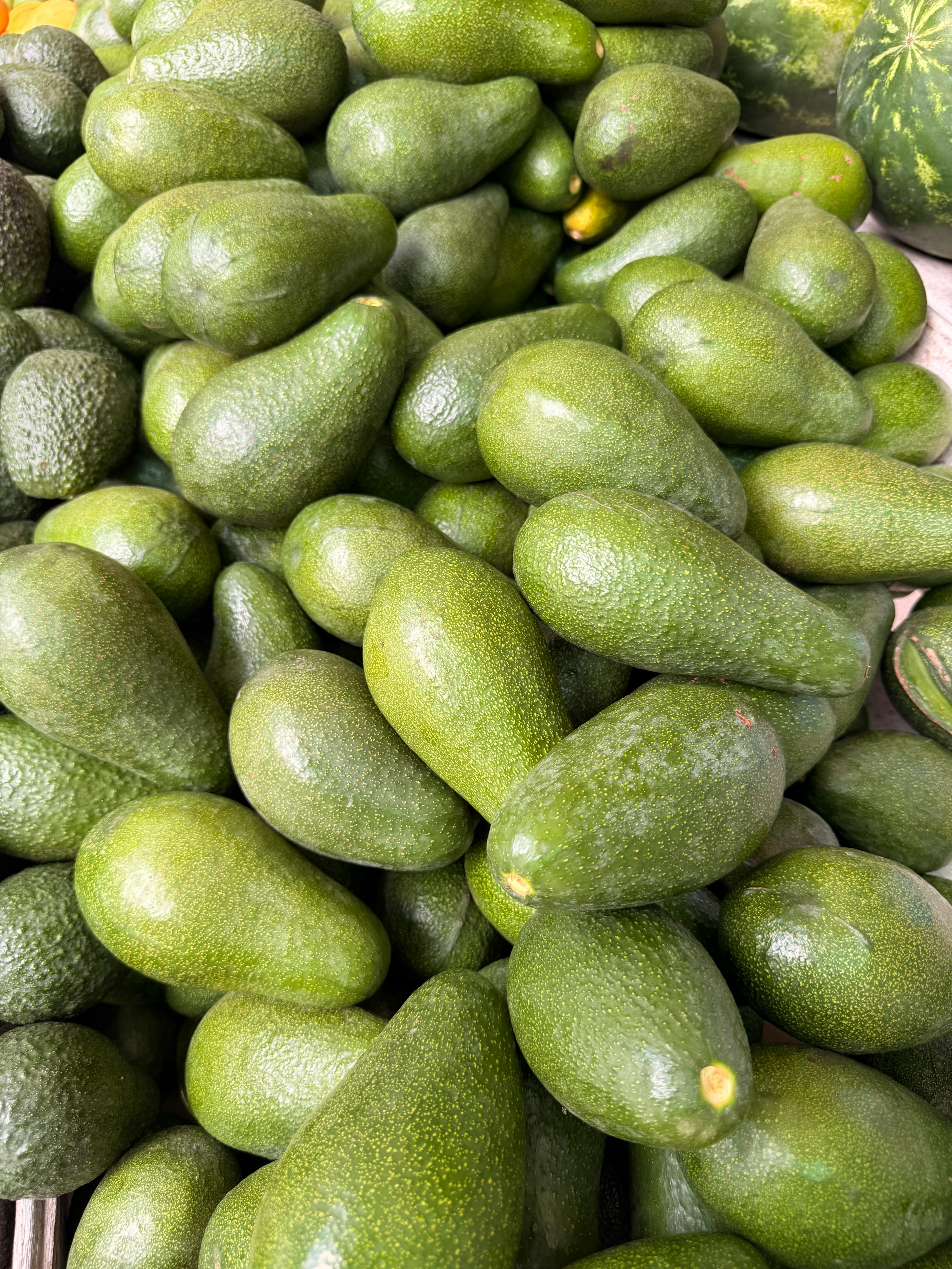 Close-up of fresh green avocados at Lima market, perfect for healthy meals.