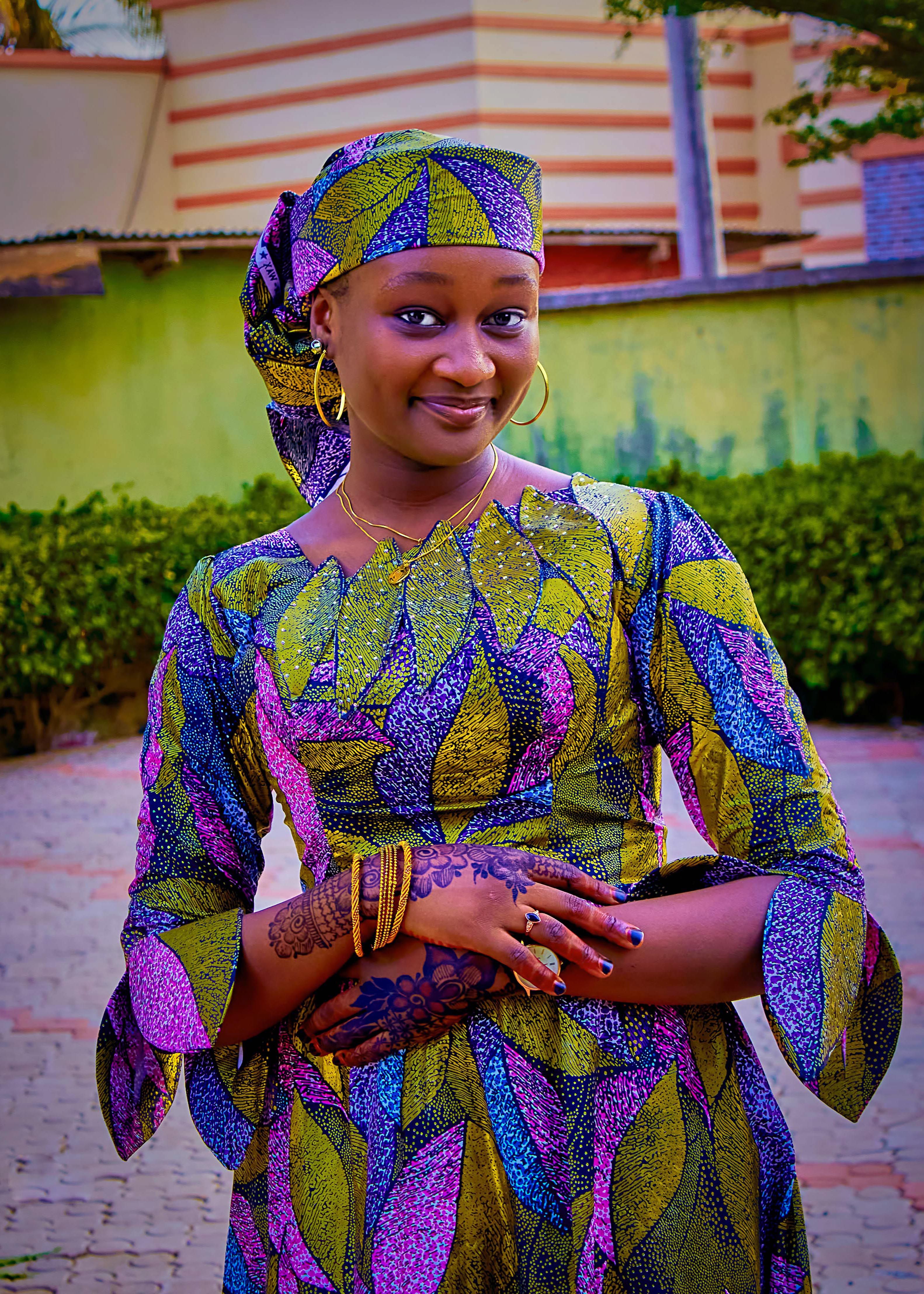 Smiling Woman in Colorful Traditional Attire Outdoors · Free Stock Photo