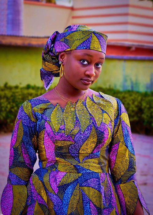 Free A stylish woman poses in a colorful traditional African print dress outdoors. Stock Photo