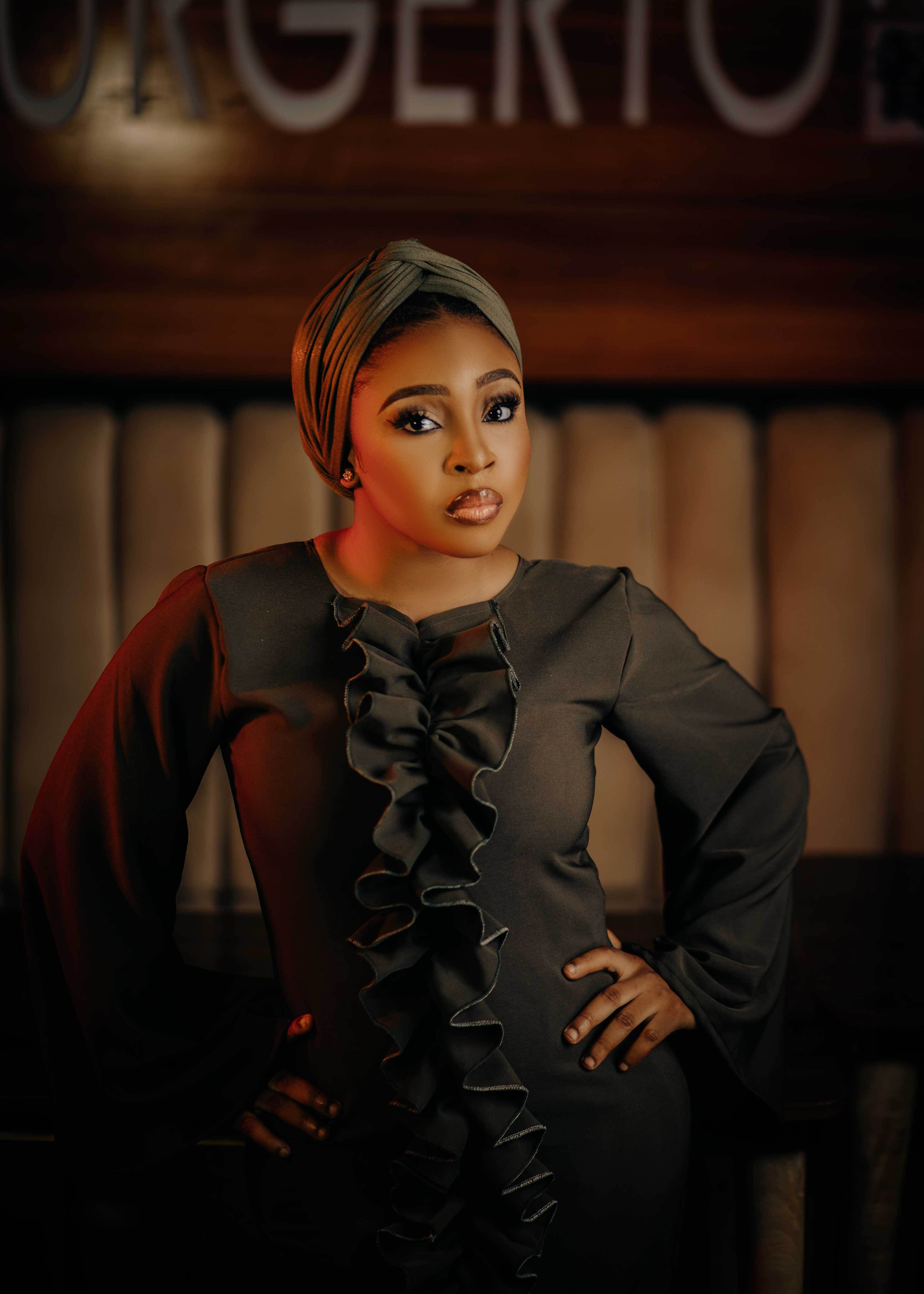 Stylish portrait of a woman in a sleek dress posing confidently indoors.