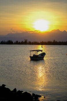 Tranquil sunrise view over Da Nang Bay with a lone fishing boat, capturing scenic beauty and serene coastal vibes.