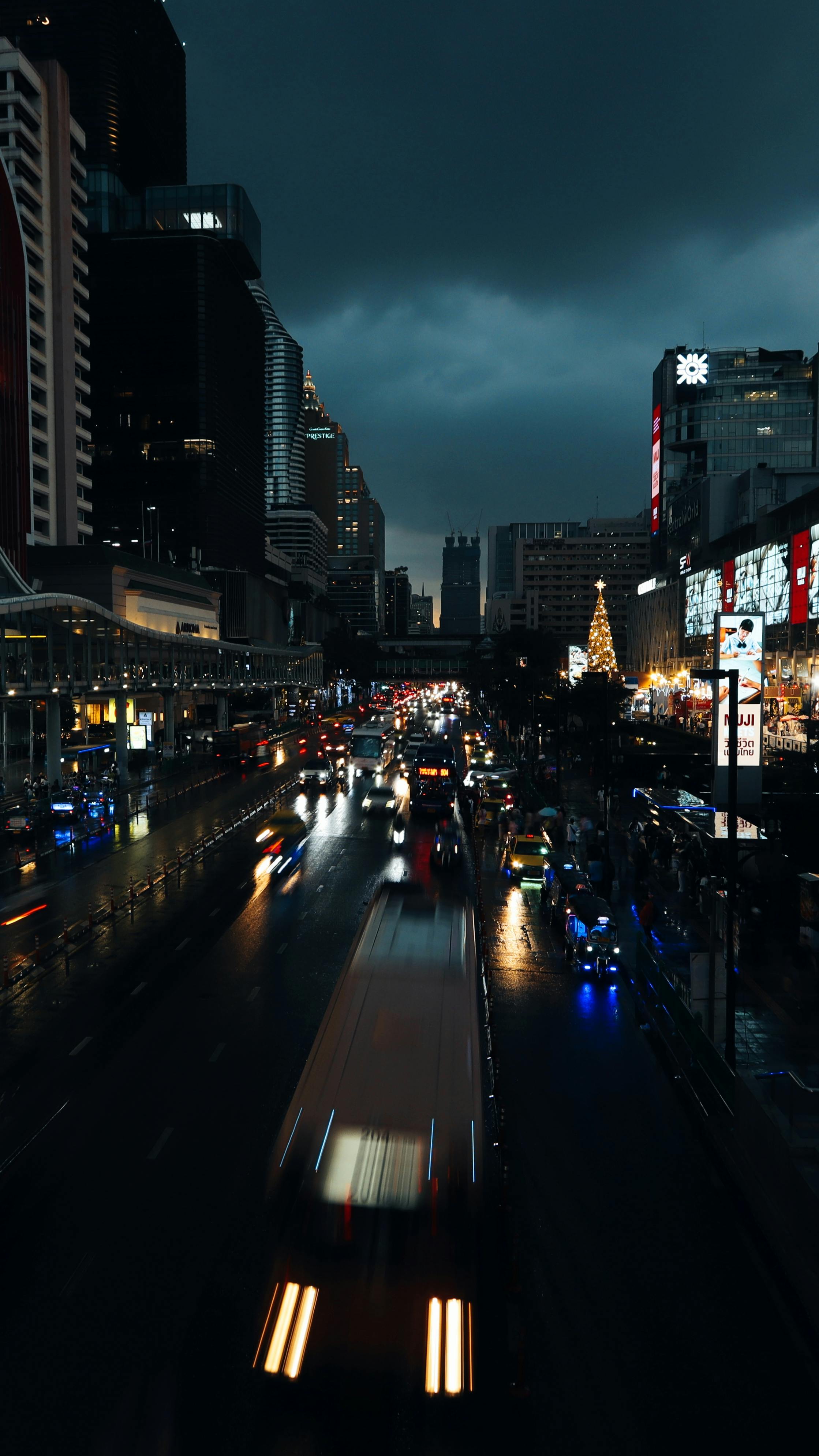 Dynamic night scene capturing bustling traffic and city lights in Bangkok, Thailand.