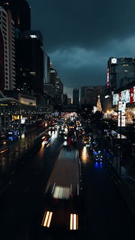 Dynamic night scene capturing bustling traffic and city lights in Bangkok, Thailand.