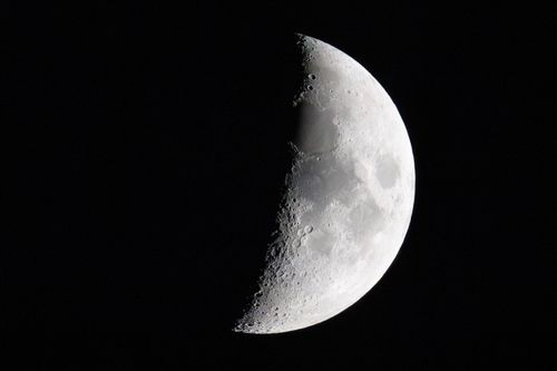 Free A stunning close-up of the half moon showcasing craters and texture against the dark night sky. Stock Photo