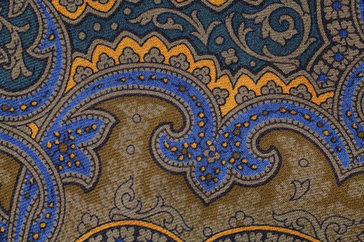 Close-up of a colorful paisley pattern fabric with intricate details and rich textures.