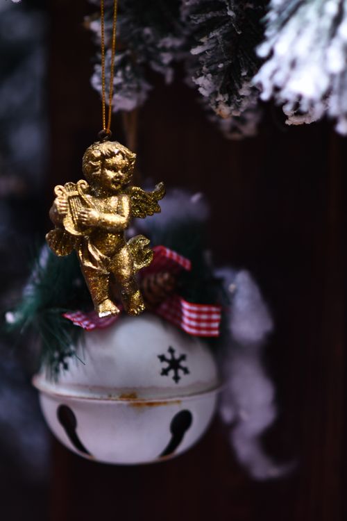 Free Close-up of a Christmas ornament featuring a golden cherub and bell with snowflakes. Stock Photo