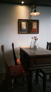 Cozy cafe setting featuring a wooden table, floral decor, and vintage art.