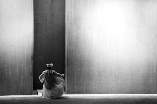 A black and white photo of a person in traditional attire at an Istanbul architectural landmark.