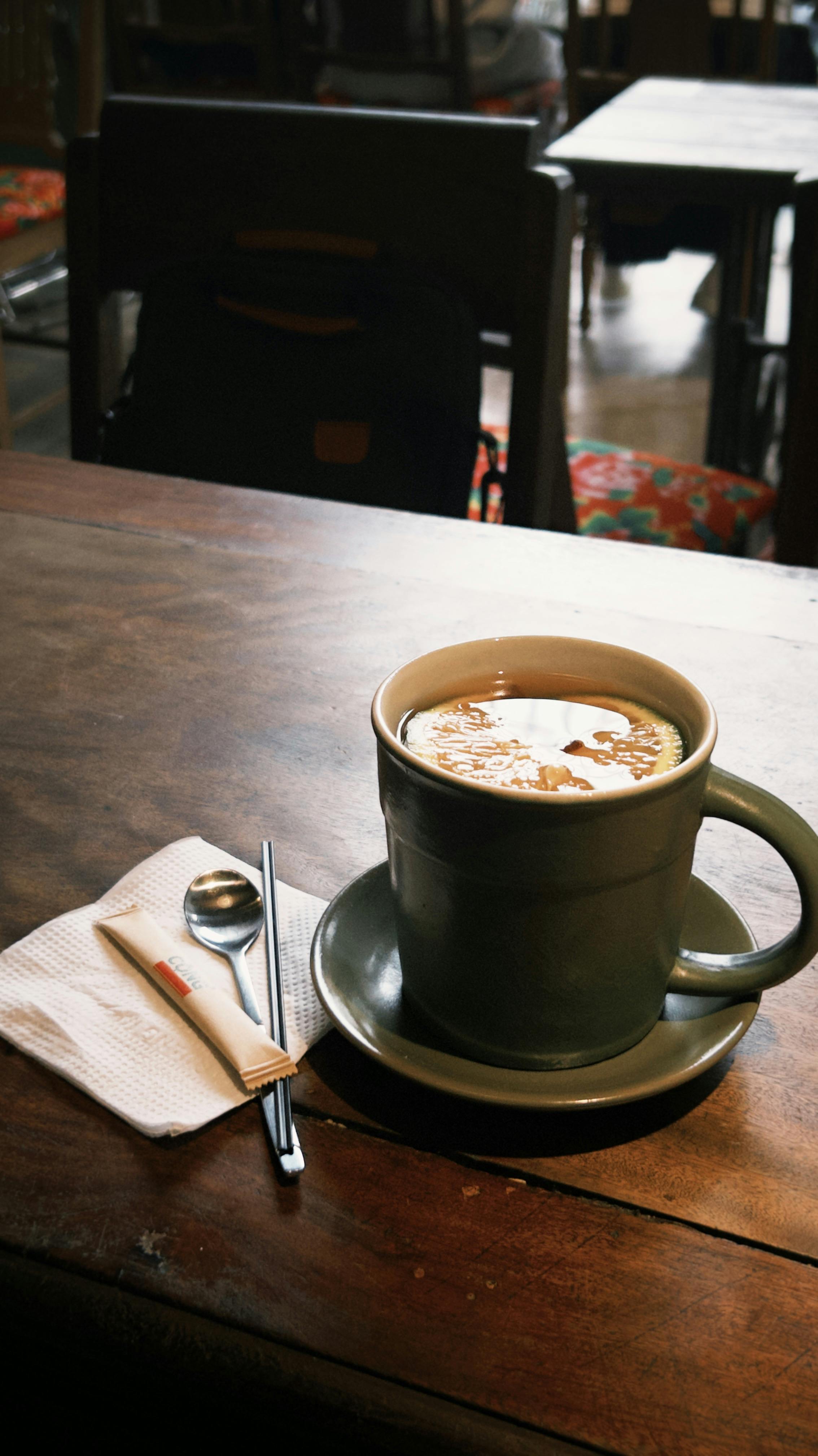 Warm coffee cup on a wooden table in a cozy cafe setting. Perfect for relaxation.