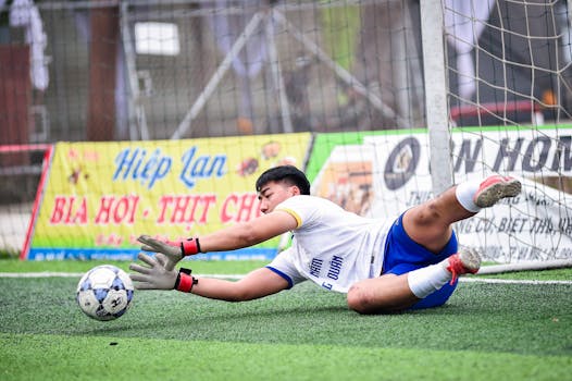 A young goalkeeper in action during a soccer match in Hà Nội, Vietnam.