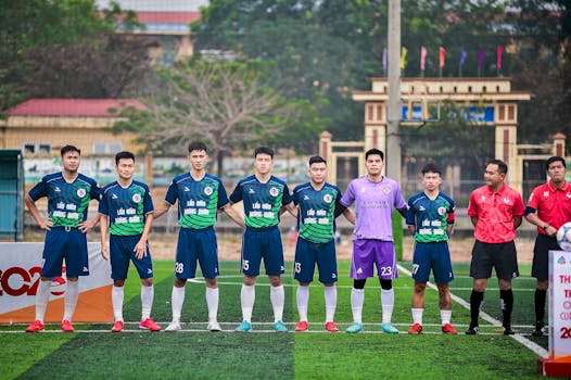 Soccer players and referees standing together on a field in Hà Nội, Vietnam.