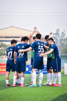 Youth soccer team huddles on a sunny day in Hanoi, Vietnam. Team spirit and sportsmanship.