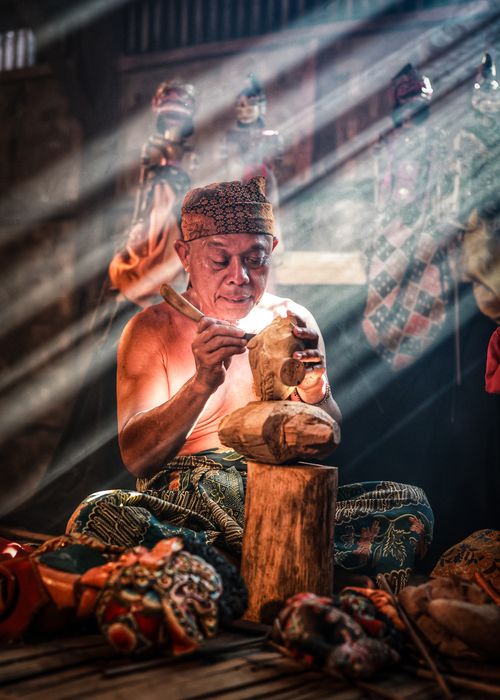 Free A skilled artisan in West Java intricately carves a traditional Javanese wooden puppet. Stock Photo