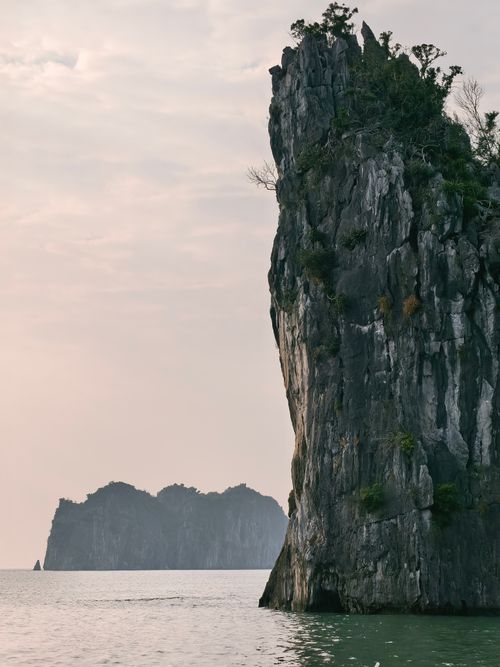 Free Serene view of towering limestone cliffs in Ha Long Bay, perfect for travel and nature imagery. Stock Photo