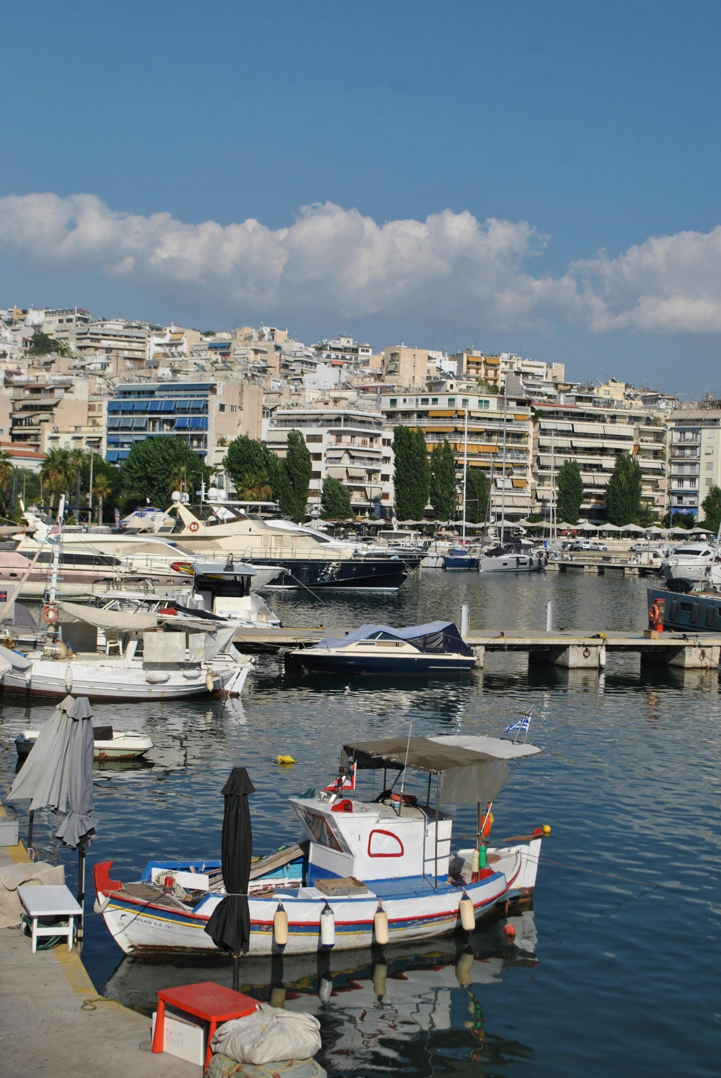 Colorful marina filled with boats against a vibrant cityscape under a blue sky.