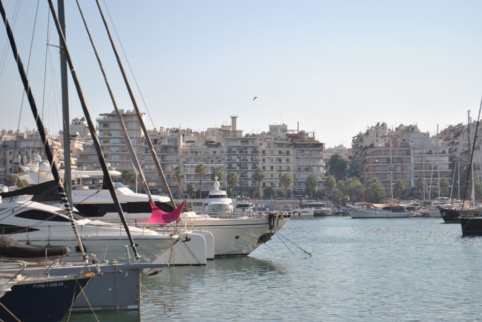 Ultimate 3 Hours Kassandra Sunset or Day Sailing Yacht Tour Review 2026 - A picturesque view of a marina with luxury yachts docked against a vibrant urban backdrop.