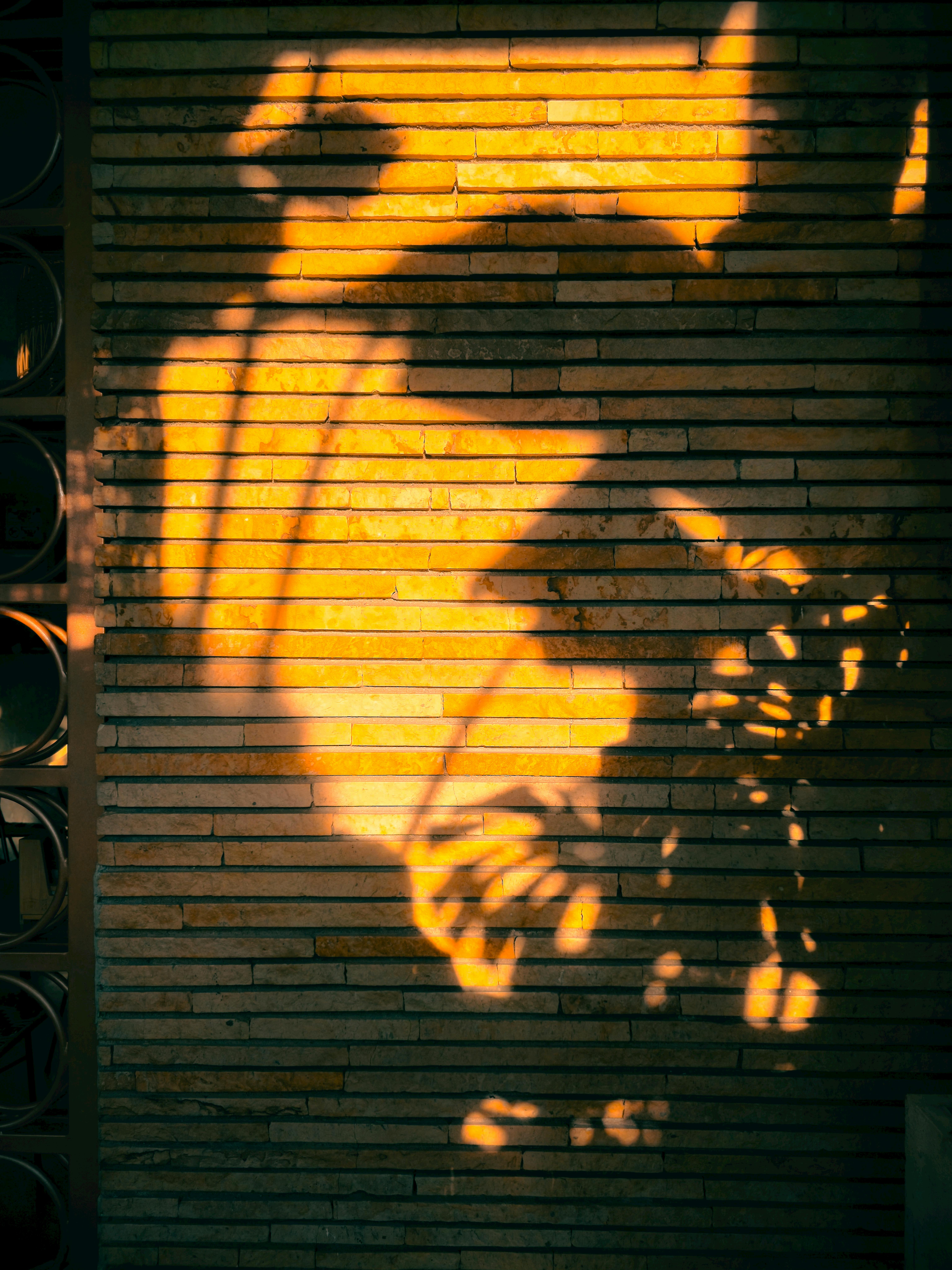 De franc Ombres càlides i captivadores que creen art abstracte en una paret de maons a Bucaramanga, Colòmbia. Foto d'estoc