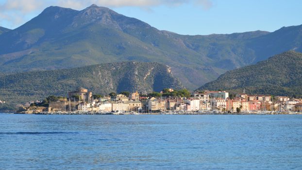 Scenic coastal view of Saint-Florent, Corsica with mountains and sea.