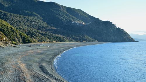 Free Explore the stunning coastal landscape of Corse, France, with its rocky beach and lush mountains. Stock Photo