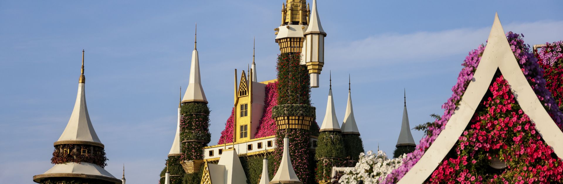 A stunning floral castle surrounded by vibrant blooms in a picturesque garden setting.