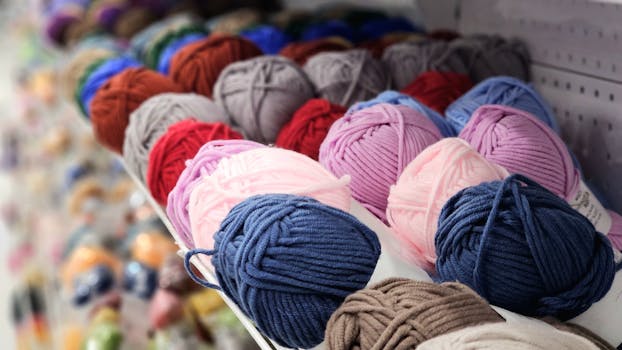 Vibrant yarn balls in a variety of colors neatly arranged on a store shelf.