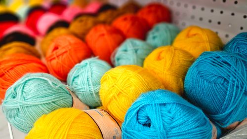 Free Vibrant yarn balls in various colors arranged on display, perfect for knitting enthusiasts. Stock Photo
