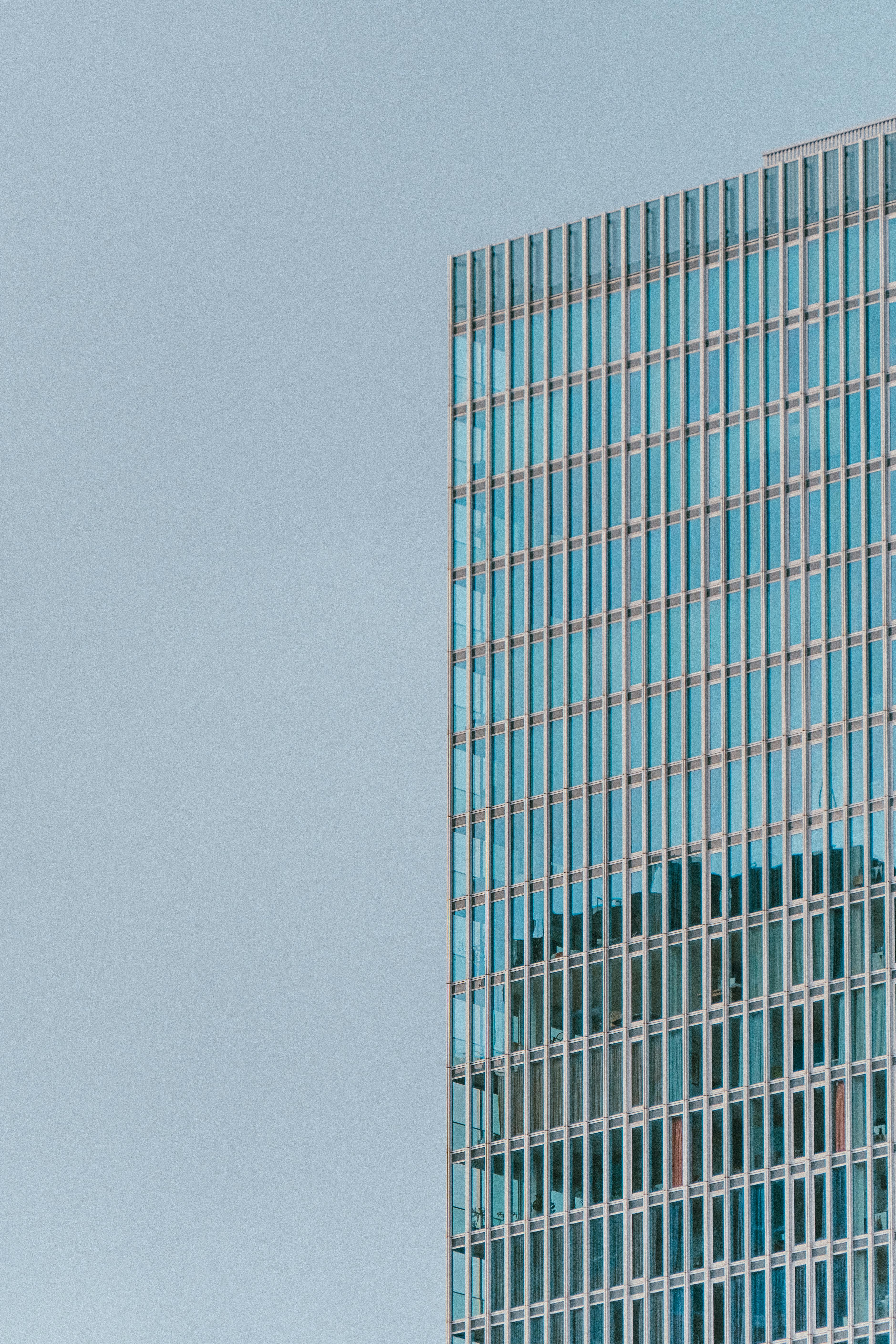 Gratis Nærbillede af en moderne glasskyskraber i Rotterdam, der fremviser arkitektonisk symmetri og blå refleksioner. Lagerfoto