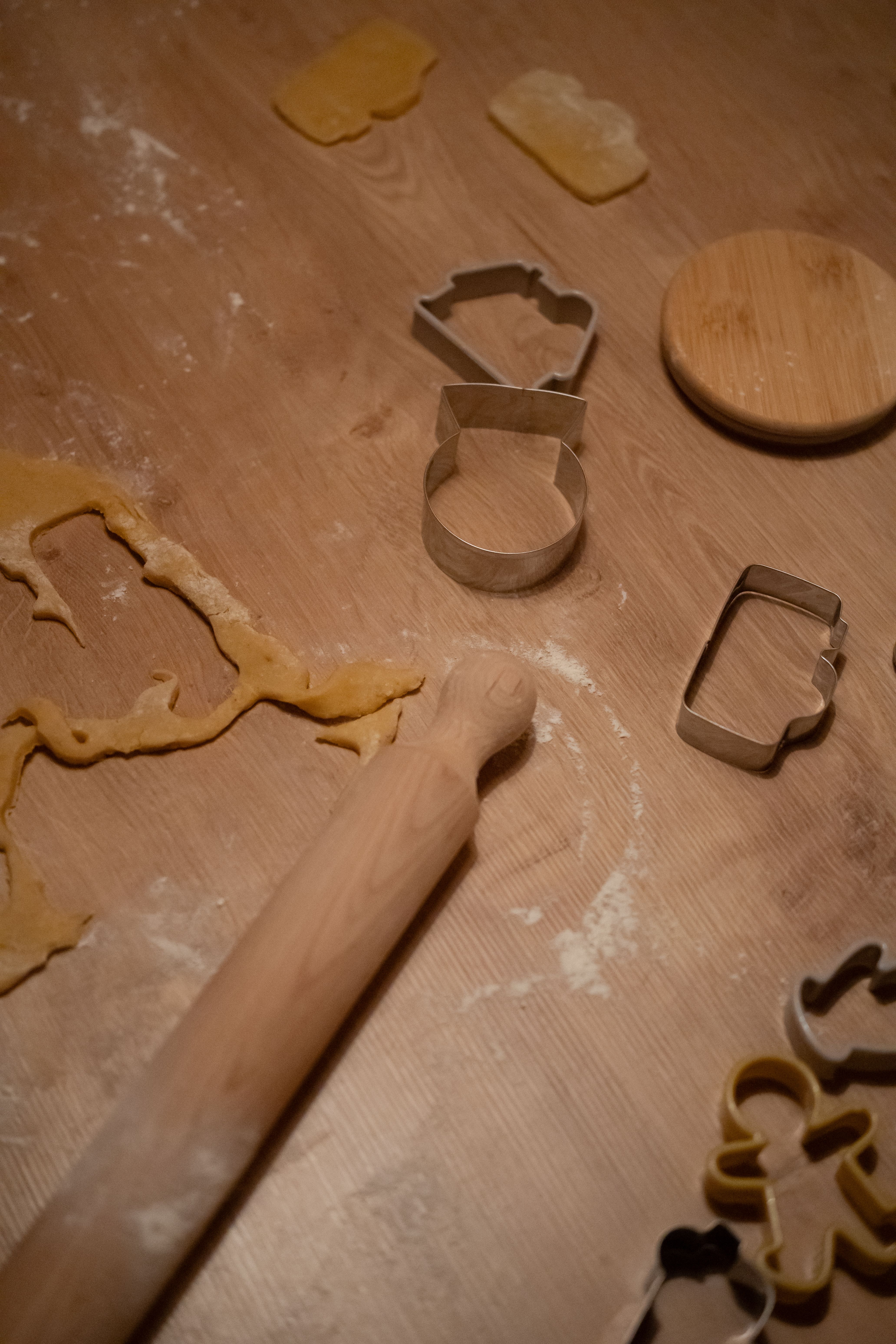 A cozy kitchen scene showing cookie dough with various cutters and a rolling pin, perfect for baking enthusiasts.