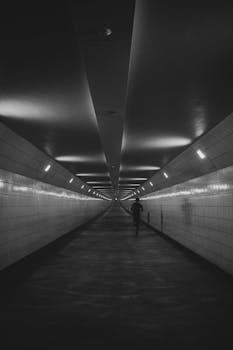 A lone figure runs through a modern tunnel in Rotterdam, captured in striking black and white.
