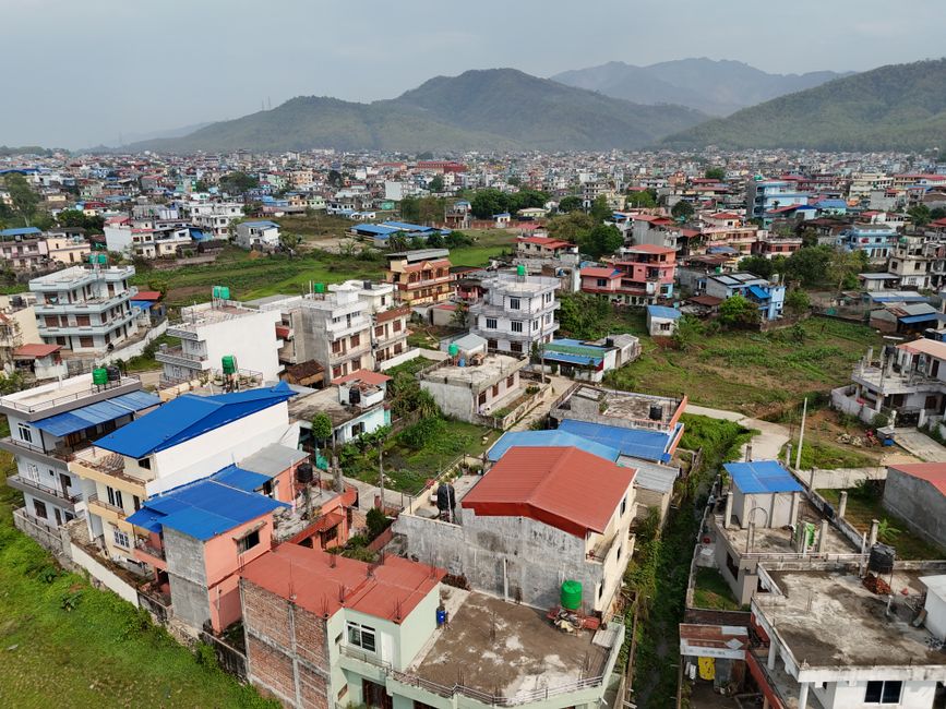 Incredible Everest Base Camp Helicopter Tour Landing at Everest View Hotel Review: A Journey to the Top of the World Review 2026 - Aerial shot of residential areas and distant mountains in Nepal, showcasing urban landscape.