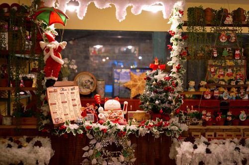 Free Colorful Christmas decorations with Santa and tree in cozy cafe setting. Stock Photo