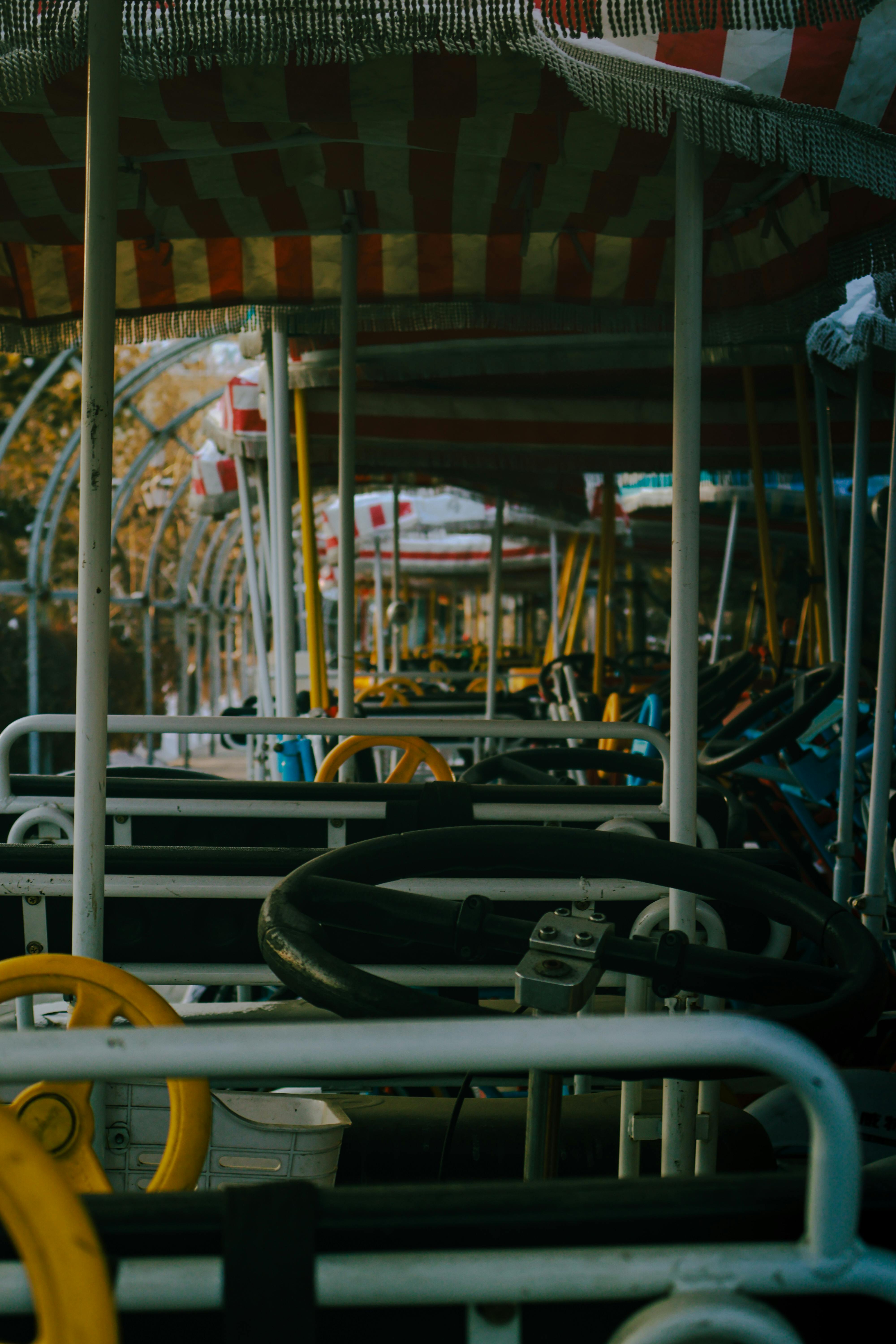 бесплатная Веломобили с полосатыми навесами, расставленные рядами, создают атмосферную вечернюю обстановку. Стоковое фото