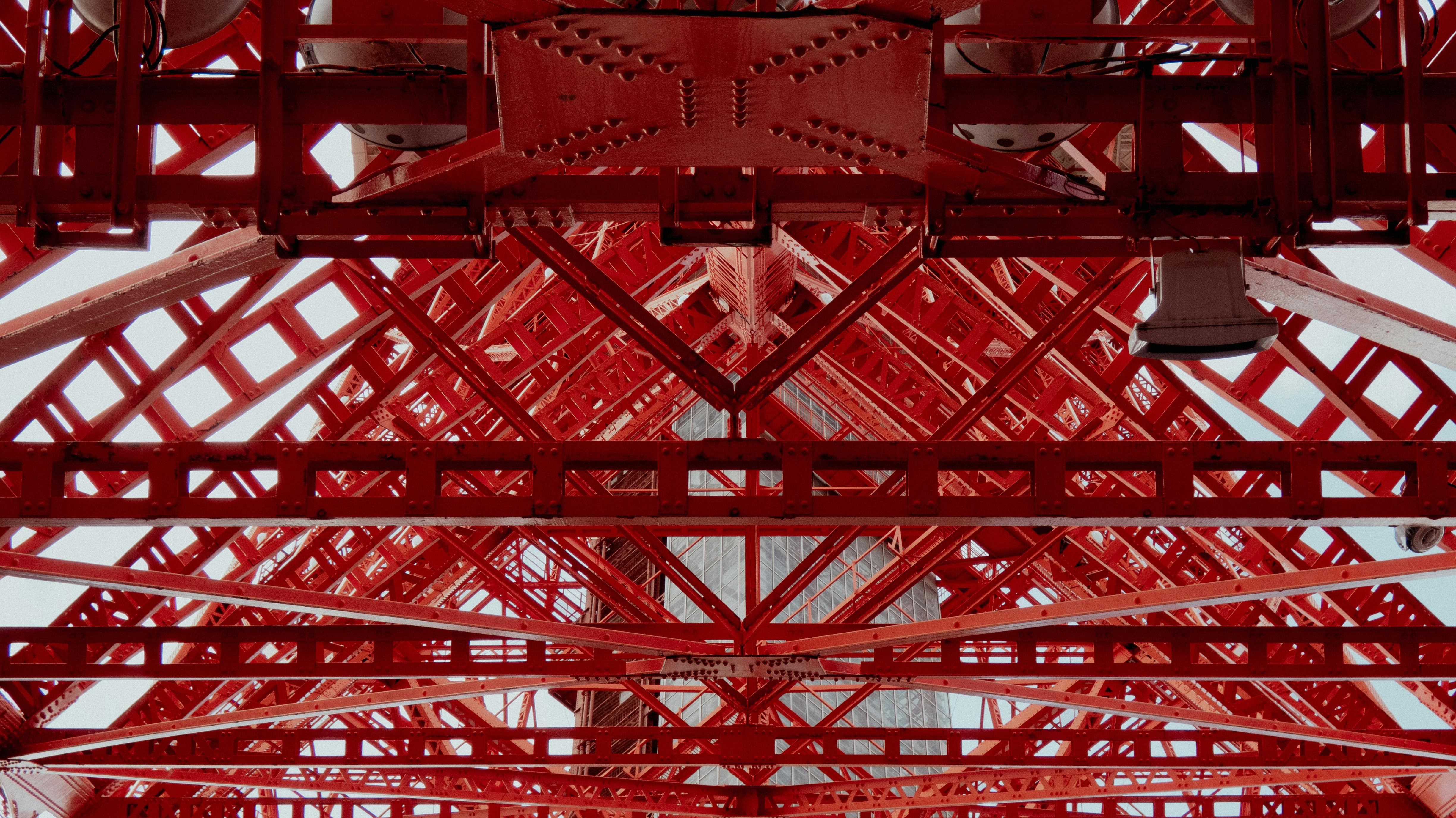 Detailed view of a red steel framework showing geometric patterns and industrial design.
