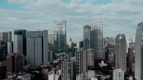 Free Aerial view of a modern city skyline featuring tall skyscrapers under a cloudy sky. Stock Photo