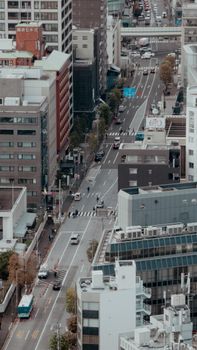 Aerial view of bustling city street with traffic and pedestrians, showcasing urban architecture.