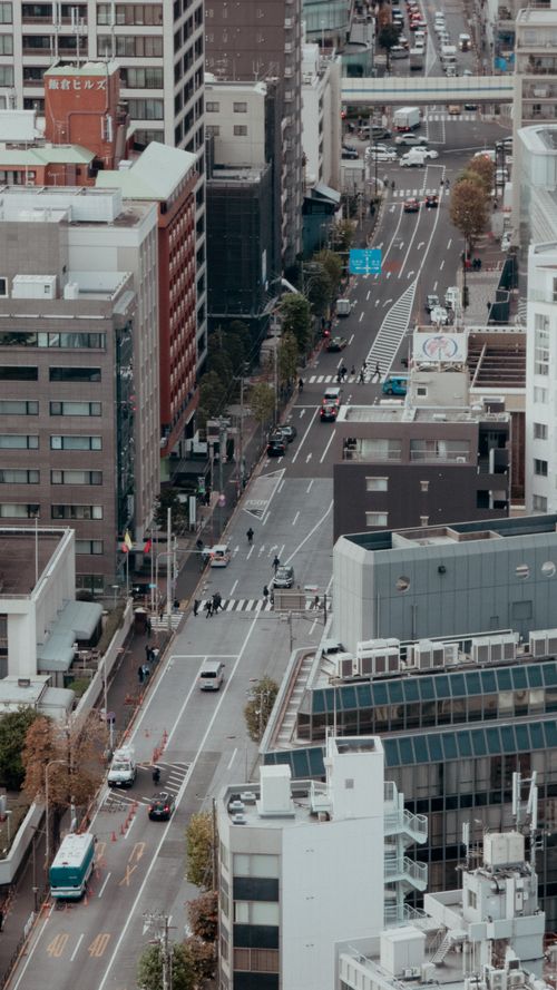 Free Aerial view of bustling city street with traffic and pedestrians, showcasing urban architecture. Stock Photo