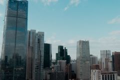 Aerial view of modern city skyline with skyscrapers against blue sky.