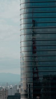 Modern skyscraper reflecting city skyline with a mountain backdrop. Captivating urban architecture.