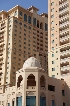 A modern high-rise building complex in Doha, showcasing unique architectural features in bright daylight.