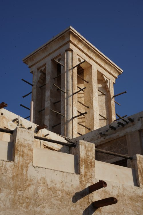 Free A restored traditional Qatari wind tower under a clear blue sky in Doha. Stock Photo