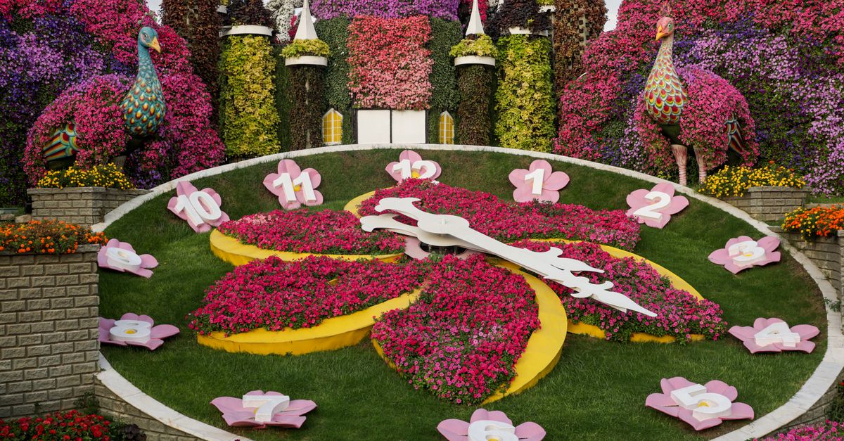 A colorful flower clock with vibrant blooms in a picturesque garden landscape.