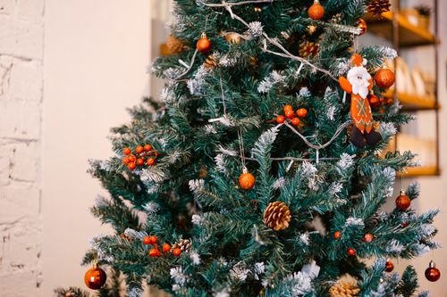 Free Brightly decorated Christmas tree with ornaments and lights in a cozy indoor setting. Stock Photo