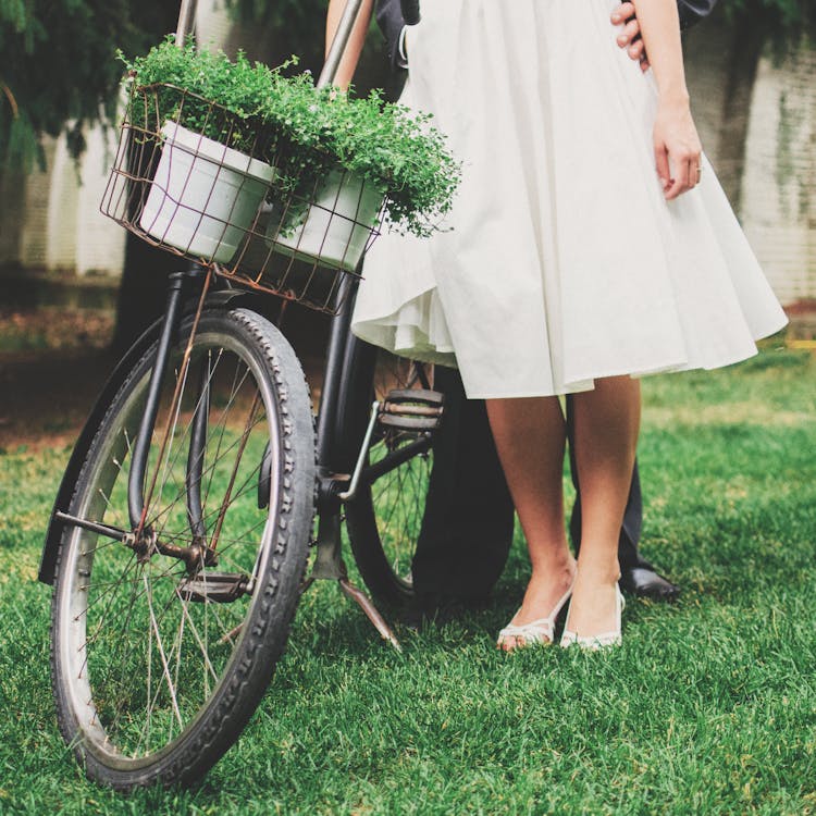 Woman And Man Standing Beside Bicycle