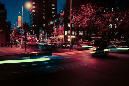 Long exposure shot of a lively London street at night with light trails and neon lights.