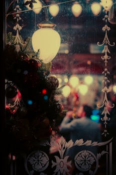 Nighttime view into a festive London pub with Christmas decorations and warm ambiance.