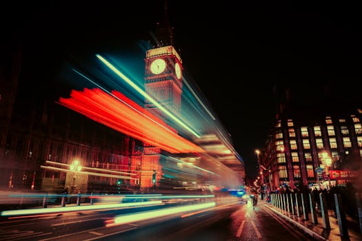 Stunning long exposure of Big Ben at night with vibrant light trails from passing bus in London.