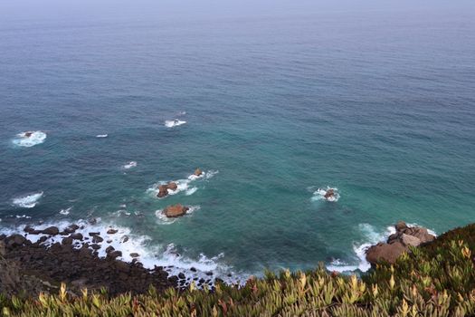 Explore the rugged coastline of Colares, Portugal with sweeping ocean views and vibrant greenery.