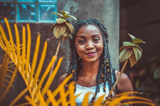 一位头发编成辫子的女人微笑着，她的肖像被植物环绕